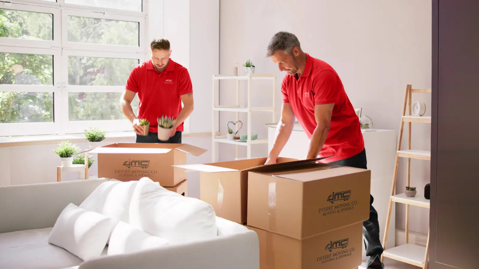 Two Desert Moving movers packing boxes in a bright living room